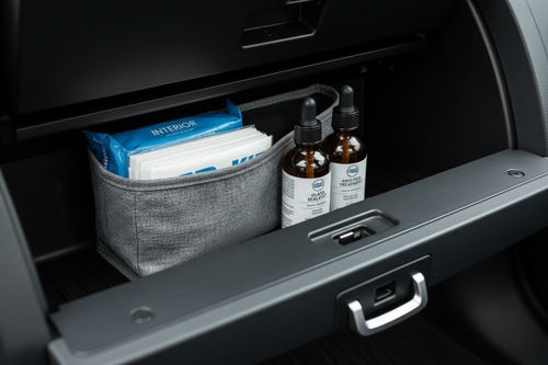 Glovebox open showing storage pouch with wipes and glass treatment bottles neatly inside