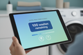 Digital wash credit balance displayed on tablet with 100 washes remaining badge