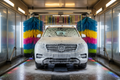 Foam-covered SUV mid-tunnel with colorful turbo foam and spinning brushes